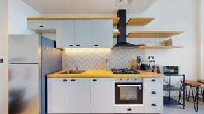 A modern kitchen with a built-in oven, a gas stove, and a stainless steel refrigerator. - Chic 1 Bed l Walking Distance to Dubai Hills Mall (Dubai)