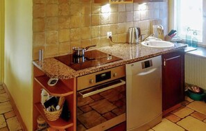 Cocina con encimera de granito, electrodomésticos de acero inoxidable y lavavajillas integrado.