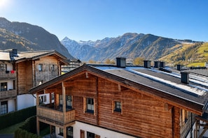 A wooden chalet with a balcony, set against a mountainous backdrop. - Vrbo Property (Kaprun)
