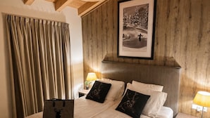 Ein Hotelzimmer mit einem großen Bett, einem hölzernen Kopfteil und einem gerahmten Bild an der Wand.