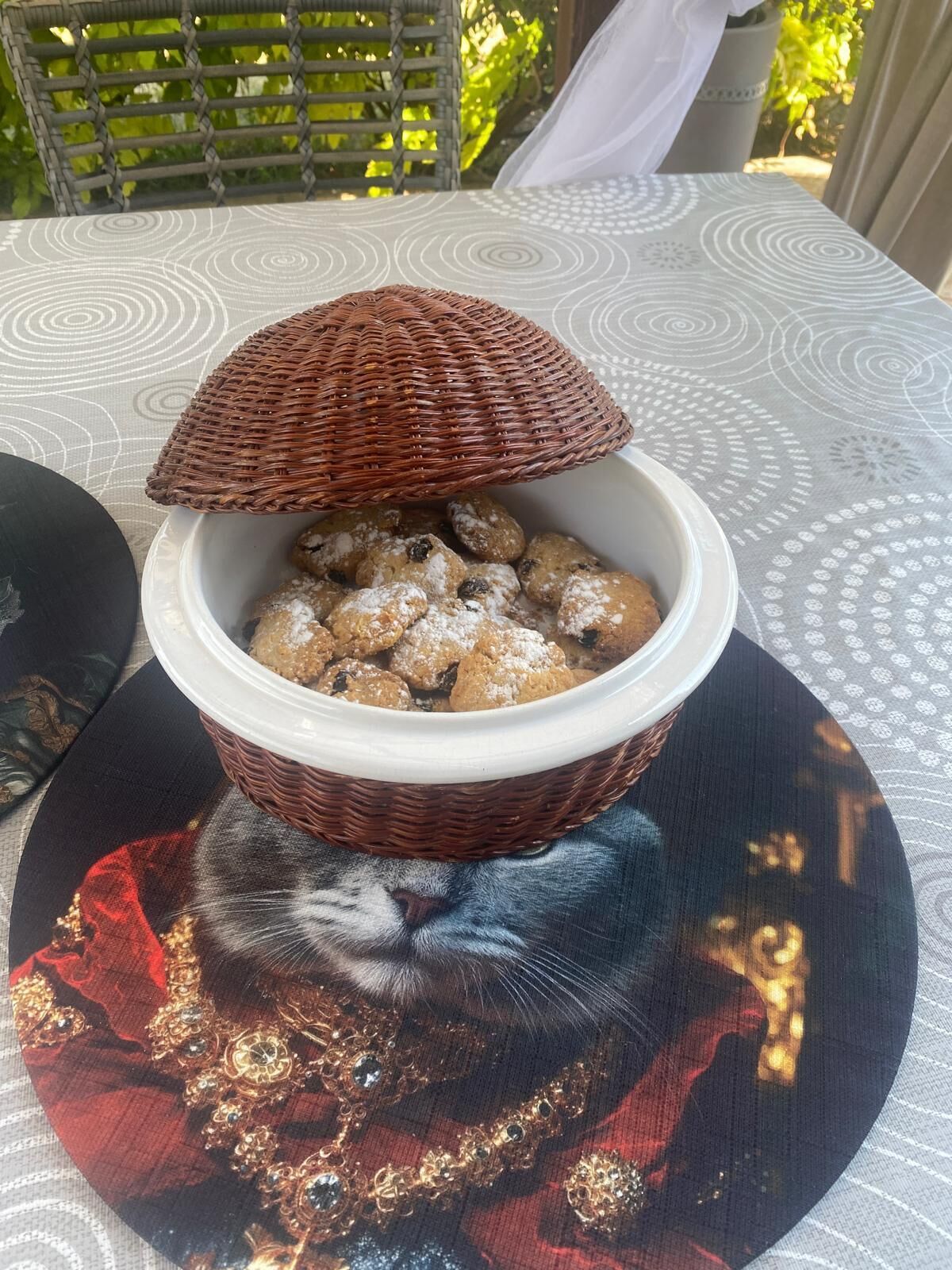 A bowl of cookies on a table with a patterned tablecloth.