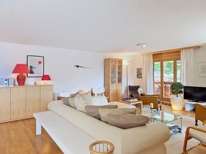 A modern living room with a sofa, a television, and a chess table. - Résidence Mila n°2 by Interhome (Crans-Montana)