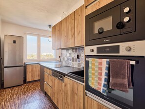 A modern kitchen with a built-in microwave, oven, and refrigerator.