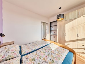 A bedroom with a double bed, wooden wardrobe, and a pendant light. - Elizabeth by Interhome (Pardubice)