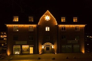 Ein Gebäude mit einem markanten, dreieckigen Dach und einer beleuchteten Sterndekoration.