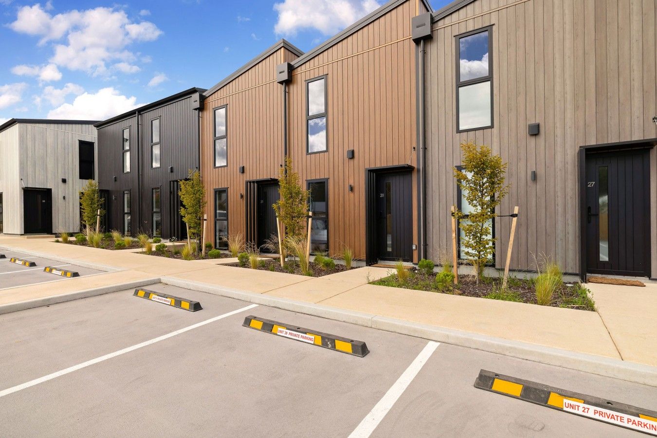 A row of modern buildings with private parking spaces.