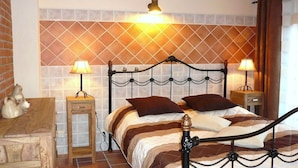 Een bed met een metalen frame, twee bedlampjes en een patroon op de muur erachter.