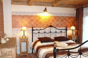 A bed with a metal frame, two bedside lamps, and a patterned wall behind it. - "PROVENCE" in the half-timbered house in Waren (Waren)