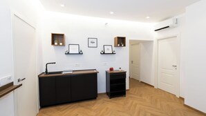 A modern interior with a reception desk, framed artwork, and a wooden floor.