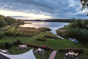 Järvenrantatontti, jossa on nurmikko, ulkotila istuimineen ja laituri.
