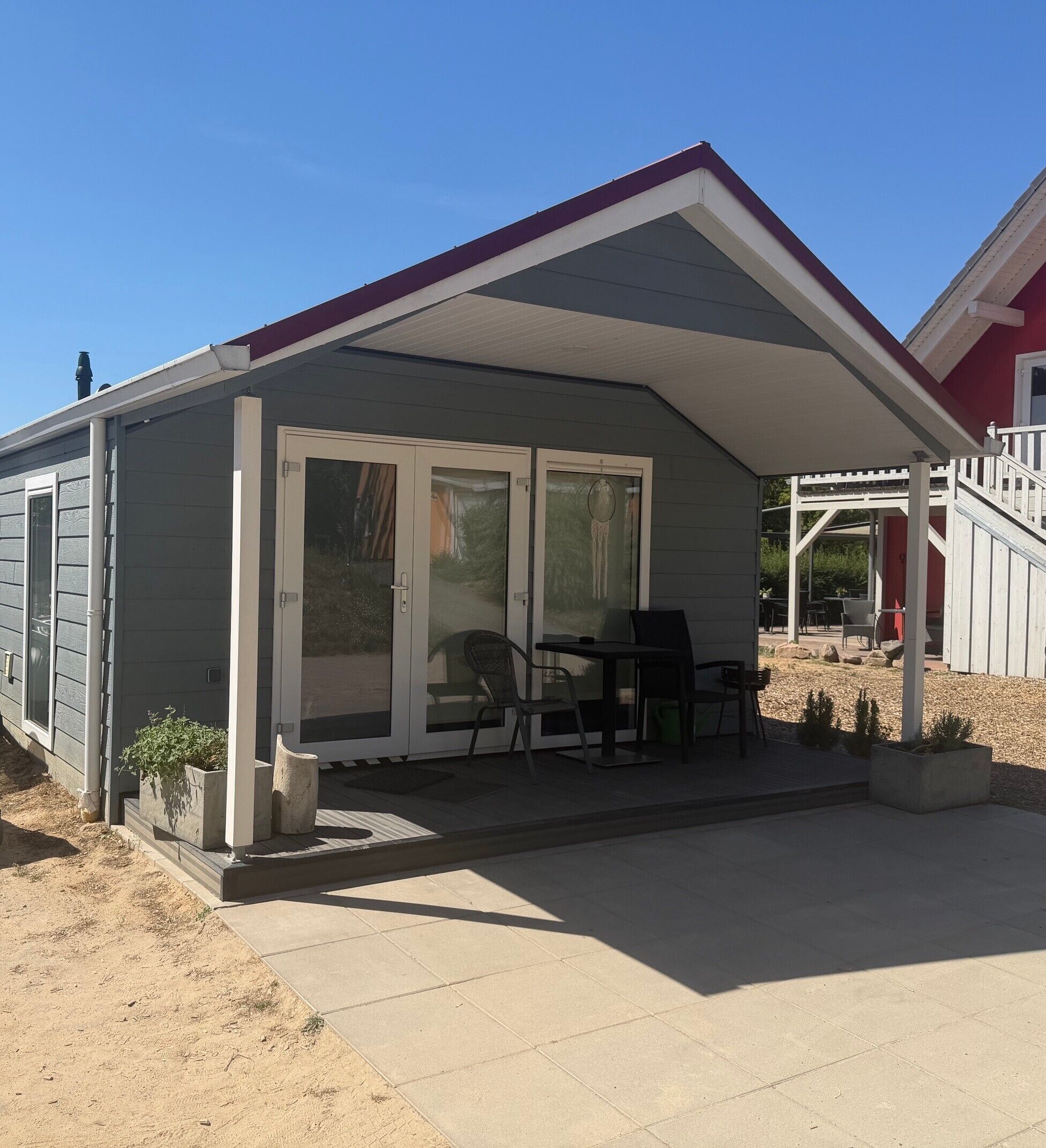 A single-story building with a covered patio area, sliding glass doors, and outdoor seating.