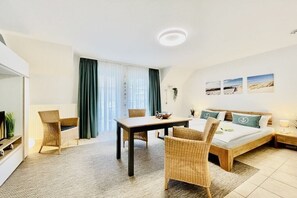 Ein Hotelzimmer mit einem Bett, einem Esstisch und zwei Stühlen.