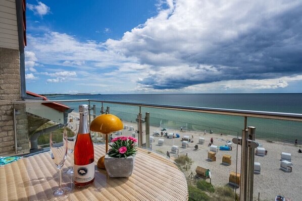 A balcony with a bottle of red wine, a glass, and a potted plant. - Exclusive tower apartment (Burgtiefe)