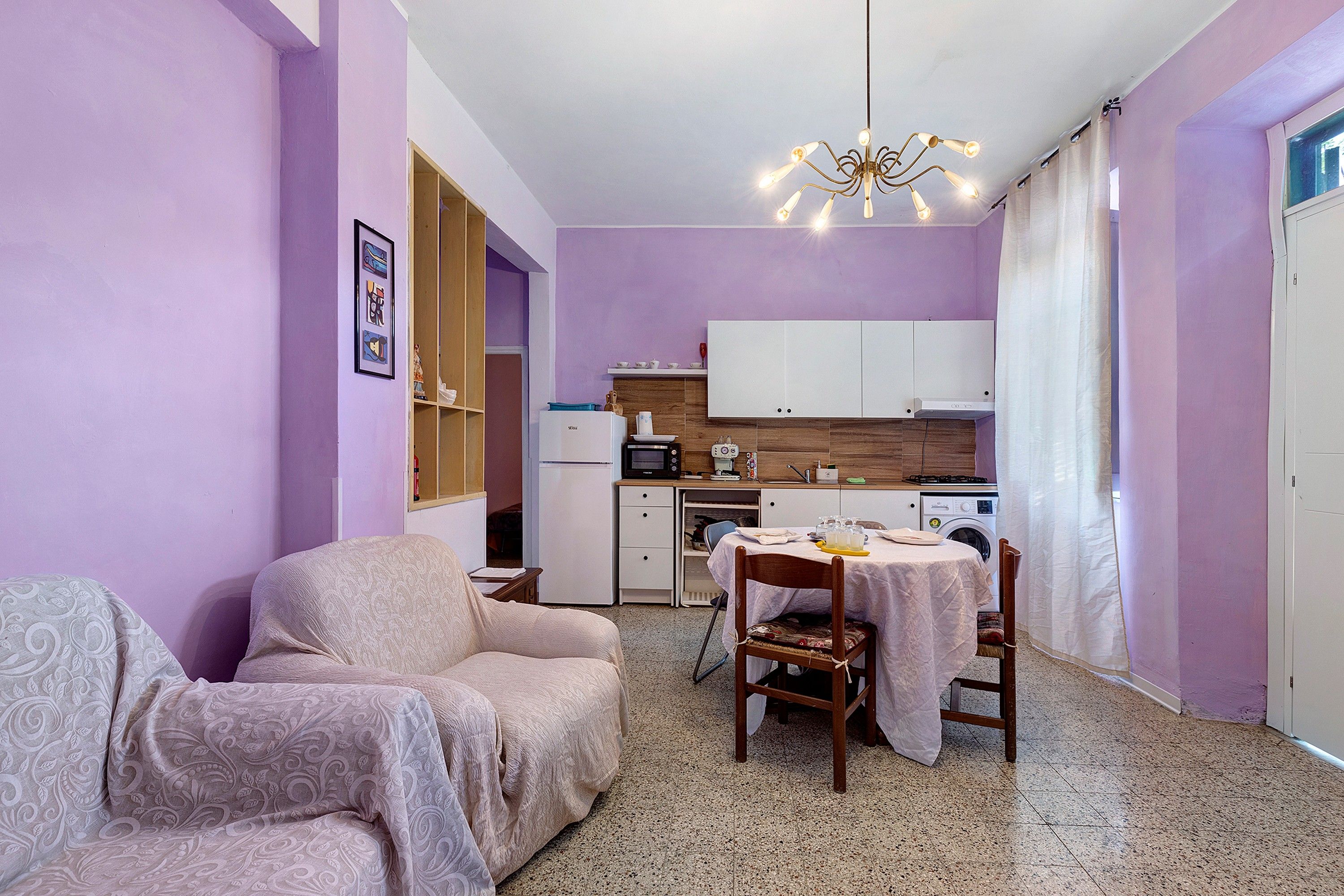 Un espacio habitable compacto con kitchenette, zona de comedor y área de descanso.