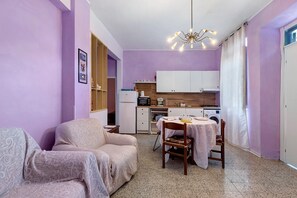 A compact living space with a kitchenette, a dining area, and a seating area.