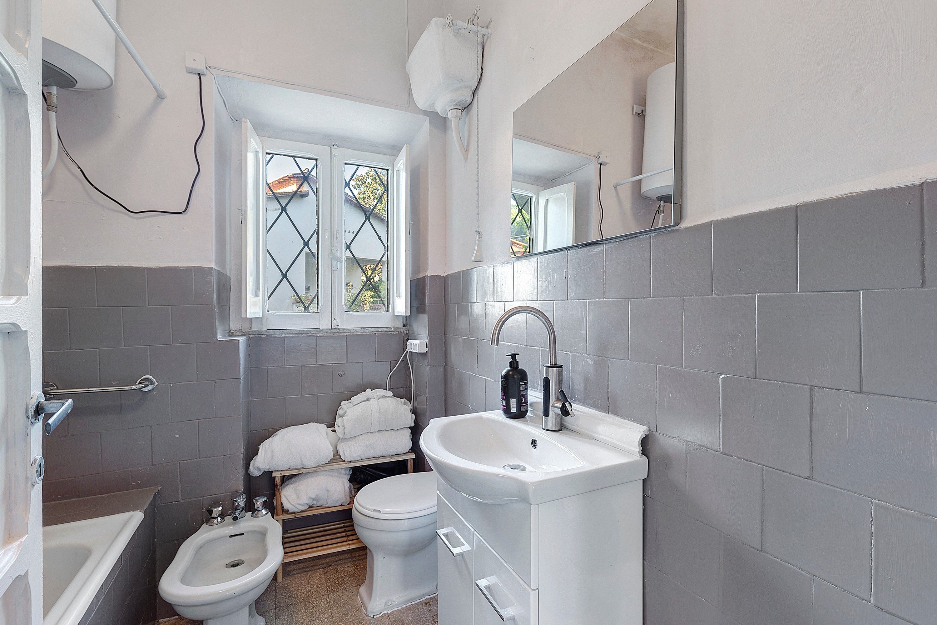 Ein kleines Badezimmer mit einer Bidet-Funktion, Toilette und Waschbecken.
