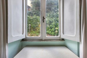 A room corner with a window, a door, and a small window seat.