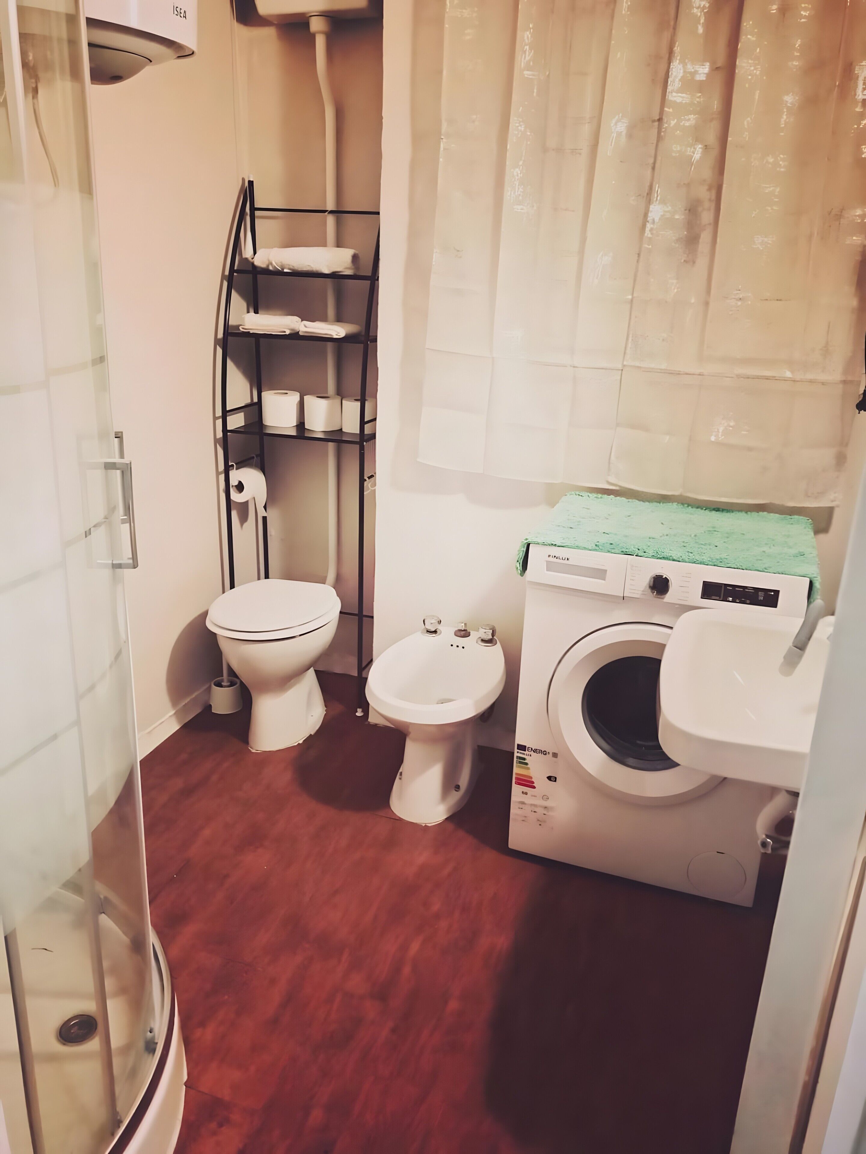 Un bagno compatto con WC, bidet e lavatrice.