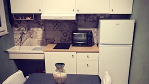 A compact kitchen with a microwave, a refrigerator, a sink, and a dining table with chairs. - 'Rifugio Del Benessere' Apartment (Monte Compatri)