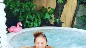 A person relaxing in a hot tub with a pink flamingo decoration and lush greenery in the background. - Holiday Home 'Enrica' with Private Terrace, Private Garden and Air Conditioning (Monte Compatri)