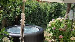 A hot tub surrounded by greenery, a pergola with a canopy, and a garden with pebbles. - Holiday Home 'Enrica' with Private Terrace, Private Garden and Air Conditioning (Monte Compatri)