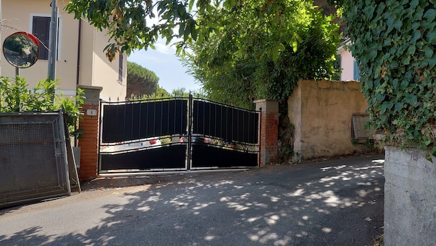 A gated entrance with a metal gate, a brick wall, and a number '6' sign. - Holiday Home 'Enrica' with Private Terrace, Private Garden and Air Conditioning (Monte Compatri)