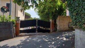 A gated entrance with a metal gate, a brick wall, and a number '6' sign.