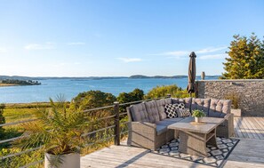 A deck with outdoor furniture overlooking a body of water. - Gorgeous home in Uddevalla with private swimming pool, can be inside or outside (Uddevalla)