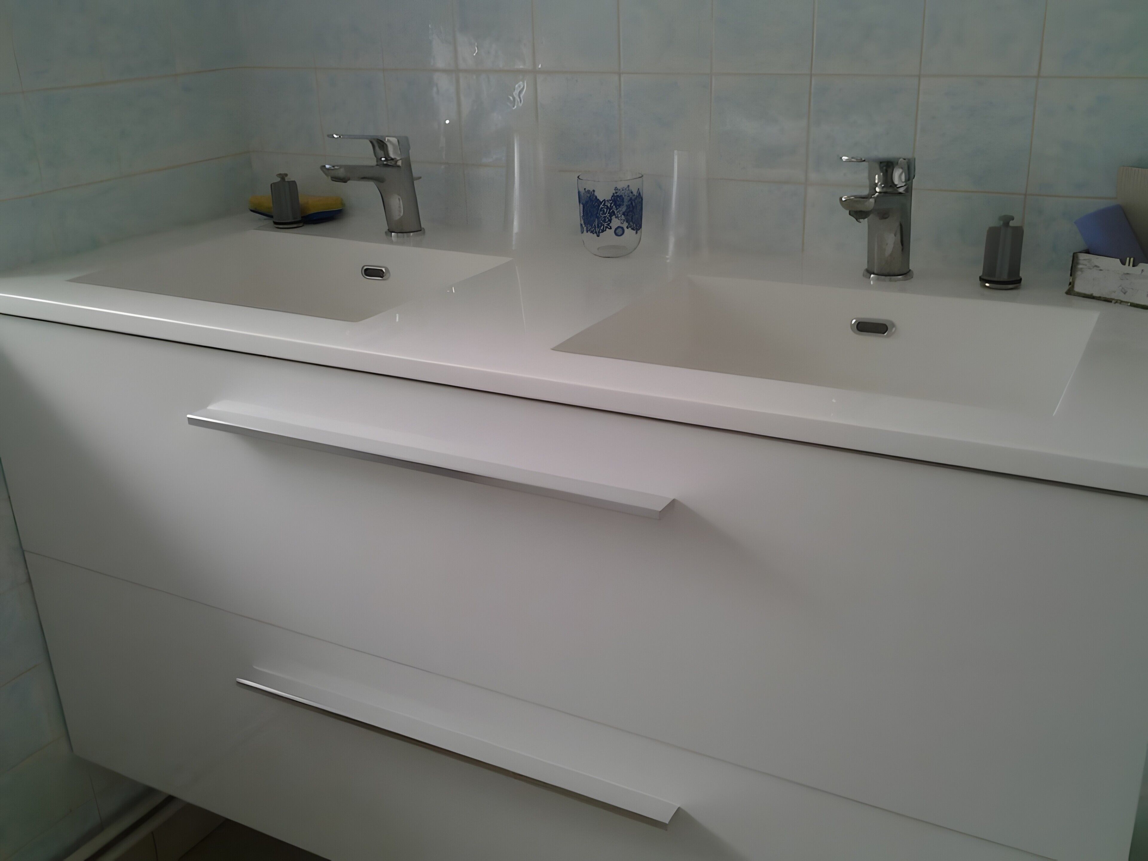 A bathroom with two sinks, a mirror, and a towel rack.