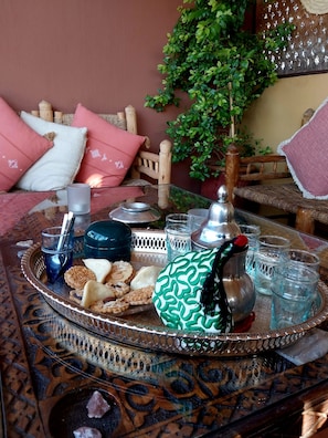 A traditional Moroccan setting with a tray of food, glasses, and a hookah on a patterned table. - Riad Dar Zampa (Marrakech)