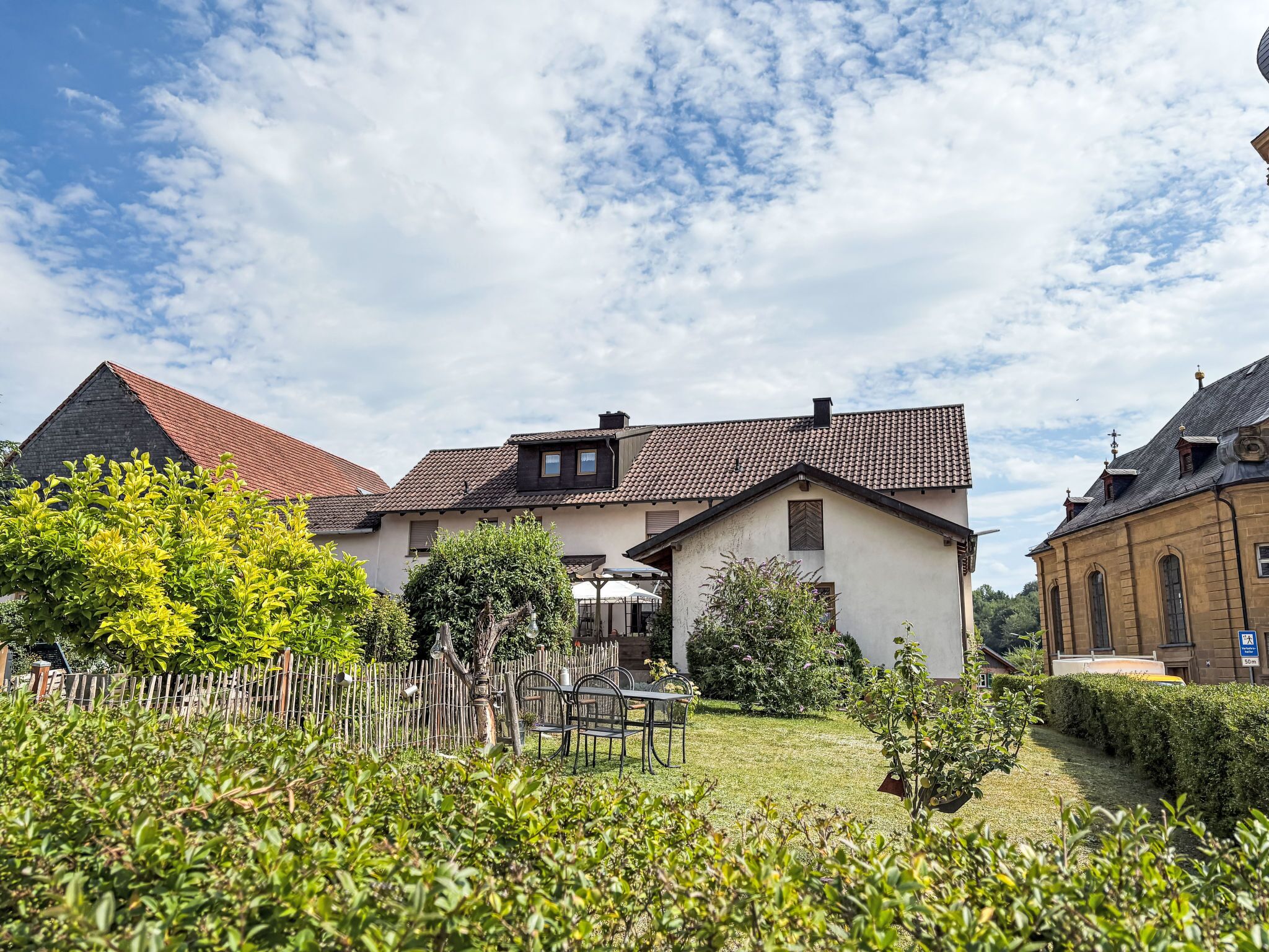 A residential area with houses, a fenced garden, and a clear sky.