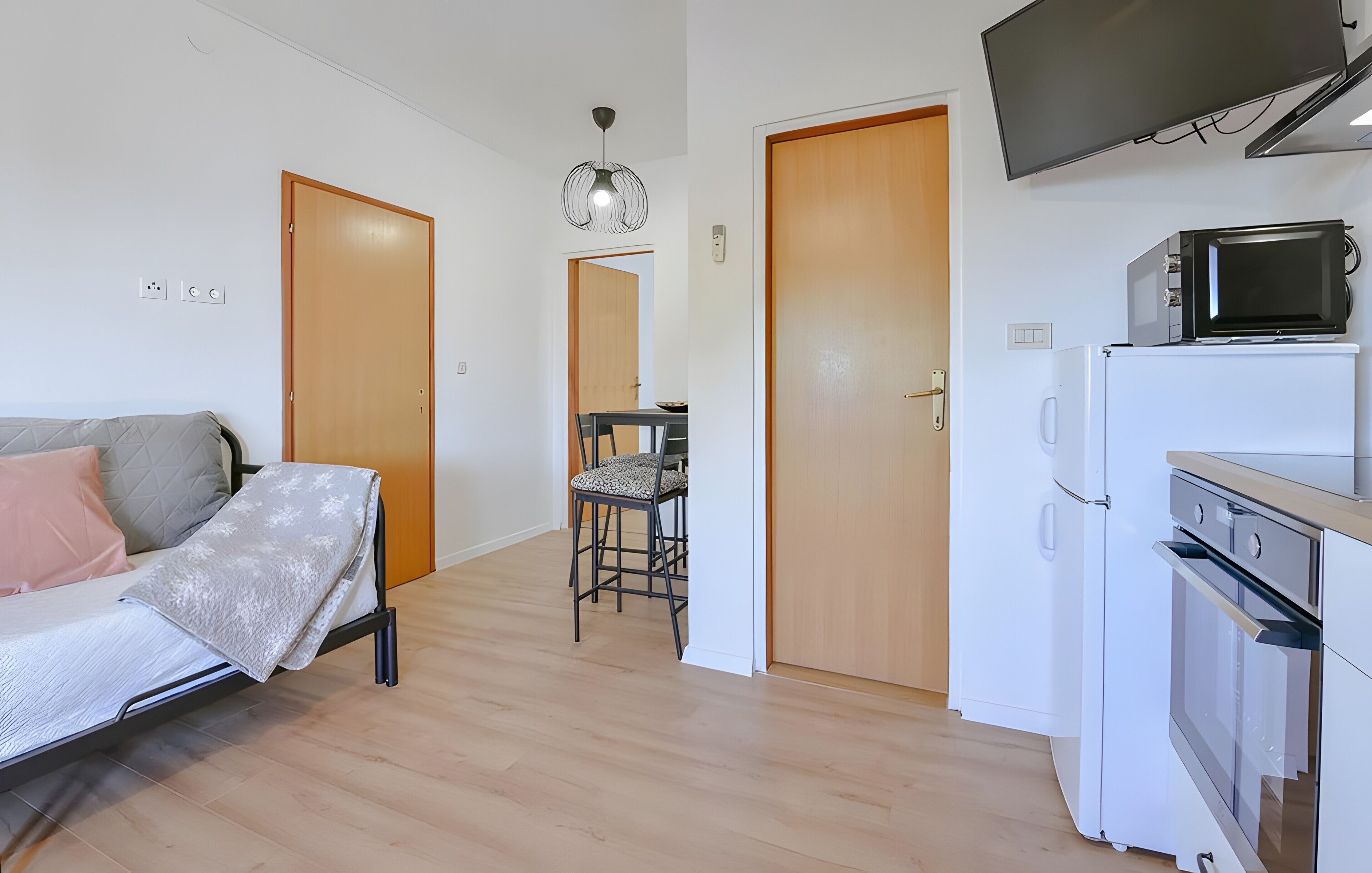 Een knus woongedeelte met een bed, een eethoek en een kitchenette.