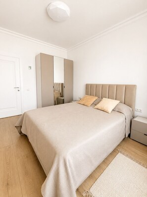 A bedroom with a bed, a wardrobe, a nightstand, and a mirror. - Vrbo Property (Chișinău)