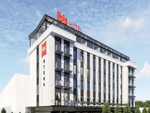 A modern hotel building with a prominent 'ibis HOTEL' sign, multiple balconies, and a clear sky. - Ibis Almaty East (Opening Autum 2026) (Almaty)