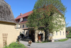 A traditional building with a red-tiled roof, a stone wall, and a wooden door. - Vrbo Property (Bahretal)