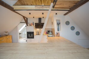 A modern kitchen with a central island, built-in oven, and a variety of appliances. - Denkmal Haus Hugo Loft Apartment with Alpine Flair and Wi-Fi (Medebach)