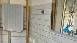 Een badkamer met een wit wastafel, een spiegel en een handdoekhouder.
