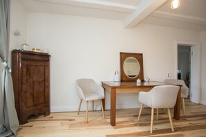 Een kamer met een houten kast, twee stoelen, een tafel en een spiegel.