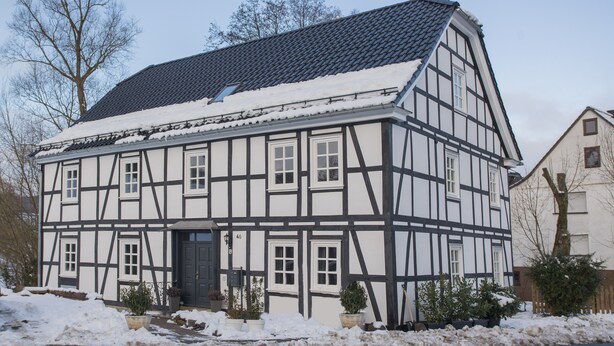 A traditional half-timbered house with a steeply pitched roof, multiple windows, and a front door. - Denkmal Haus Hugo OG Apartment with Garden View and Wi-Fi (Medebach)