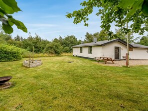 A single-story house with a well-maintained lawn, a picnic table, and a fire pit. - "Söffren" - 450m to the fjord by Interhome (Øster Assels)