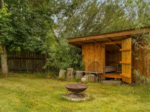 A rustic wooden cabin with an open door, a metal fire pit, and a wooden fence in the background. - "Söffren" - 450m to the fjord by Interhome (Øster Assels)