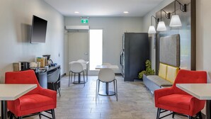 Une chambre d’hôtel moderne dotée d’un coin repas, d’un téléviseur à écran plat et d’un canapé.