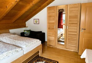 Un dormitorio con una cama, un sofá, un armario y techo de madera.