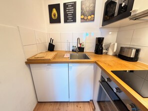 Eine Küche mit Holzausziehtisch, Spüle, Kaffeemaschine und Toaster.