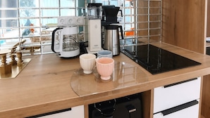 A kitchen with a coffee maker, a toaster, and a kettle on the counter. - Vrbo Property (Uhldingen-Mühlhofen)