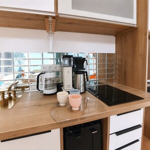 A kitchen with a coffee maker, a toaster, and a kettle on the counter. - Vrbo Property (Uhldingen-Mühlhofen)