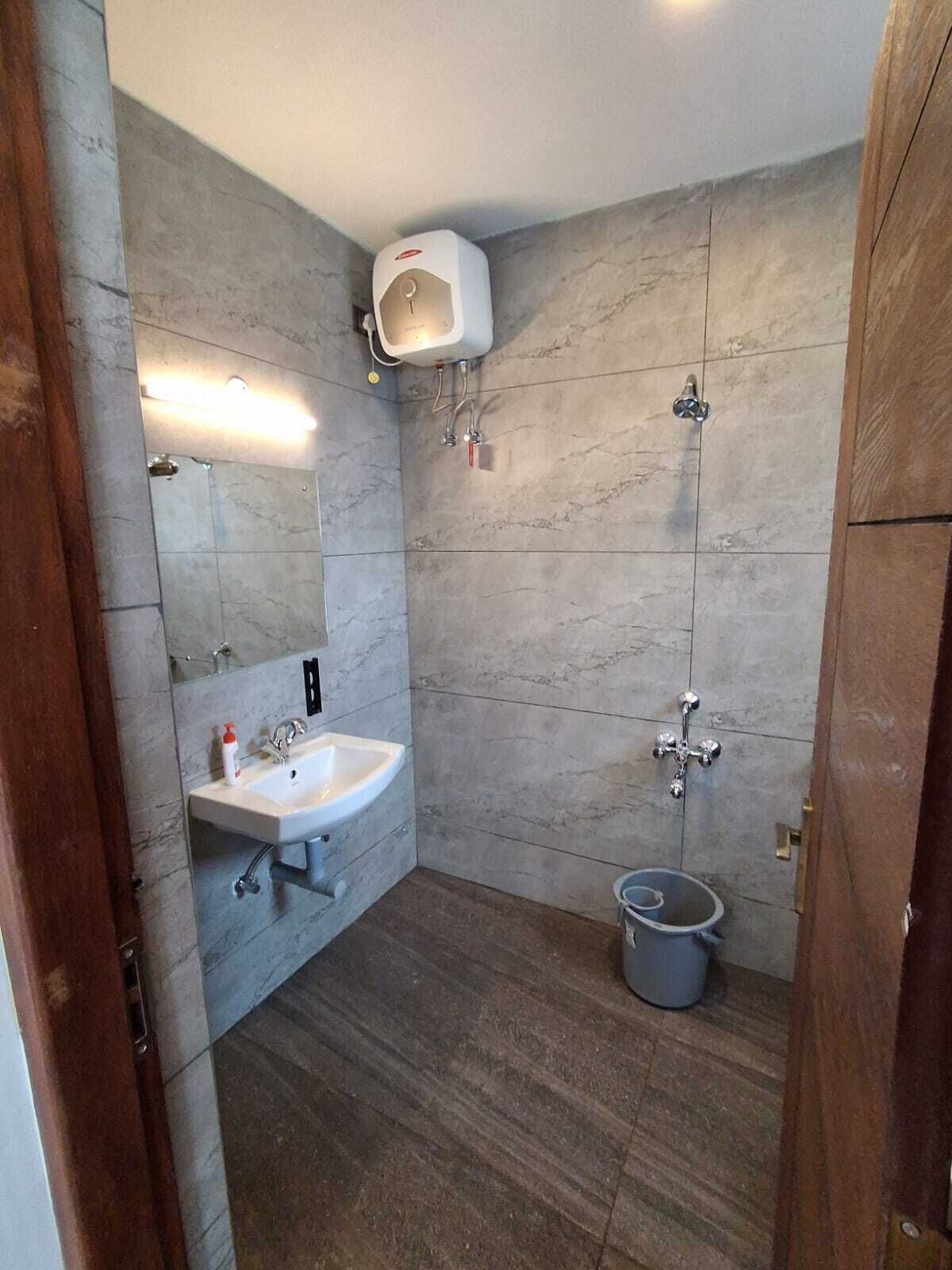 Casa de banho com lavatório, espelho e chuveiro.