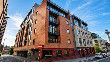 A multi-story building with a brick facade, large windows, and a no entry sign.