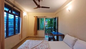 A bedroom with a bed, a desk, and a ceiling fan. - Hotel Forestway Hostel and Backpackers (Pokhara)