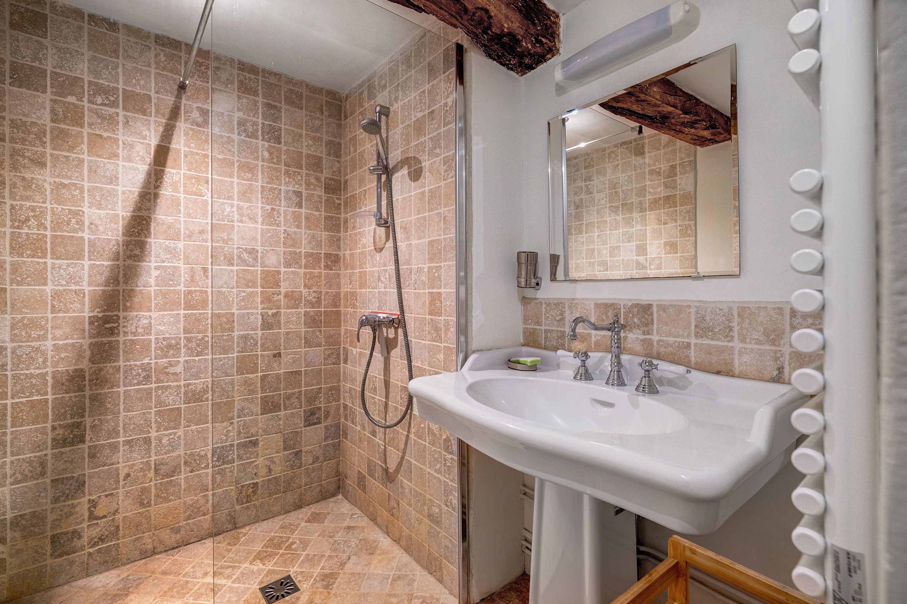 Un baño con ducha, lavamanos y espejo.